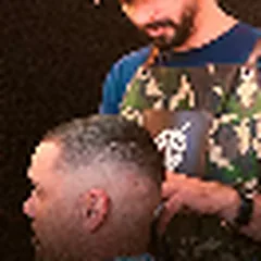 Barbeiro fazendo degradê na nuca de um cliente