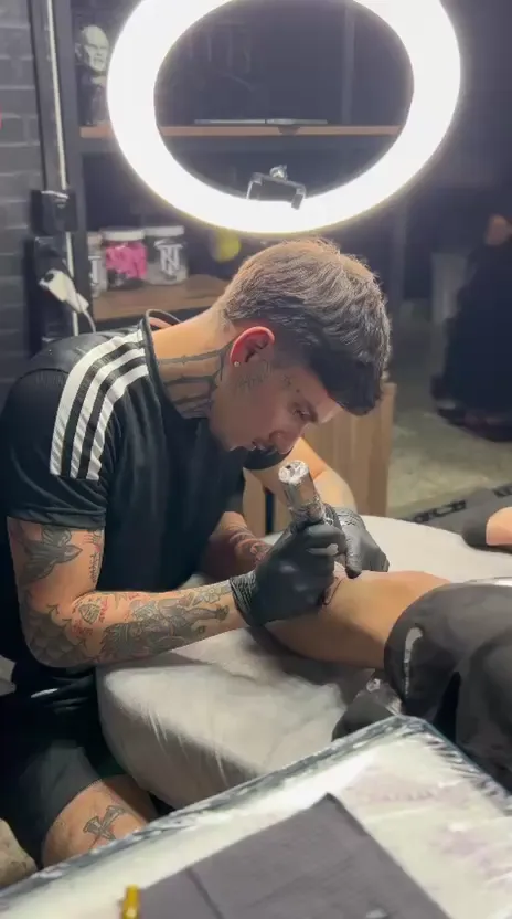 Nicolas Zaza tatuando no estúdio, sob a luz do ring light